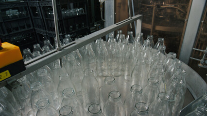 Empty glass bottles moving on conveyor belt in