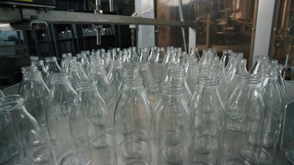 Empty glass bottles moving on conveyor belt in