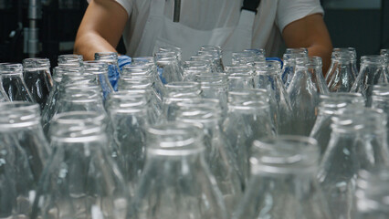 Cheesemaker preparing empty glass bottles for