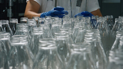 Food technologist working with empty glass bottles
