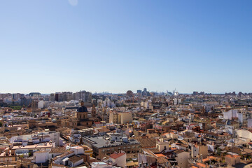 Obraz premium Panoramic view of Valencia's urban landscape showcasing diverse architectural styles and bustling city life under a clear blue sky.