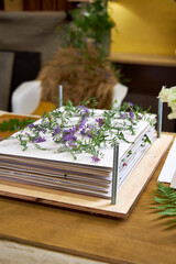 Delicate purple wildflowers arranged between sheets in a wooden flower press. A botanical drying step captured from above in a home workshop