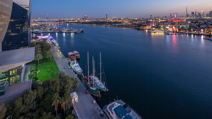 Dubai creek landscape day to night timelapse with boats and ship near waterfront