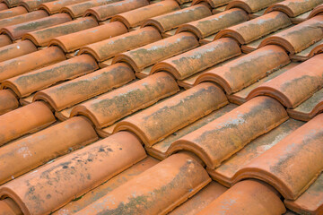 Clay tile roof in hot country, terracotta tiles protecting building from sun, traditional roofing material for warm climates, concept of architecture, construction company, travel agency