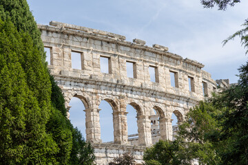 Ancient stone amphitheater stands majestically among lush greenery, showcasing architectural...