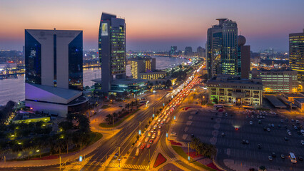 Fototapeta premium Dubai creek landscape day to night timelapse with boats and ship near waterfront