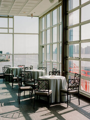 Elegant dining area with large windows overlooking the waterfront in a modern restaurant during the day