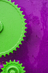 Huge iron gears painted green on a purple background. Purple and green background mechanic banner....