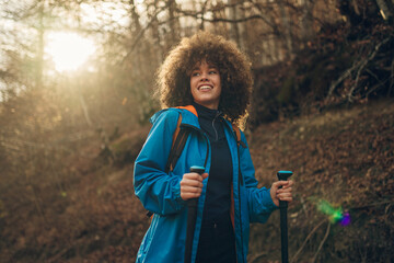 Young hiker exploring forest trail during sunny autumn day