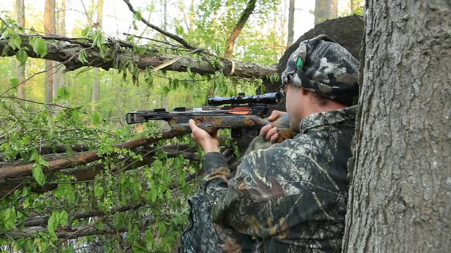 Man hunting with crossbow for Turkey in woods 