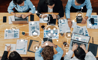 A diverse business team engages in collaborative discussion at a wooden table, surrounded by...