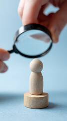 Fototapeta premium Wooden figure examined under magnifying glass examination inspection