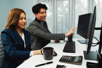 Asian business partners pointing to profit highest dynamic stock exchange data on computer screen value rate online website program. Investor showing financial on real time at modern office. Infobahn.