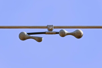 Photograph of an old and dirty steel cable tensioner on a transmission line in regional Australia.