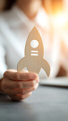 Wooden rocket ship held by person in white shirt with warm light spaceship launch