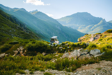 Person Preparing for Camping Beside White Van in Rocky Meadow at Lac de Ch&acirc;teaupr&eacute;, Switzerland