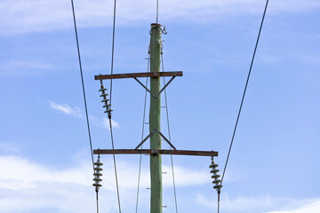 Photograph of the top cable section of an old style wooden electricity transmission line support pole typically used in regional parts of Australia.