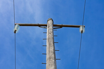 Photograph of the top cable section of an old style wooden electricity transmission line support pole typically used in regional parts of Australia.
