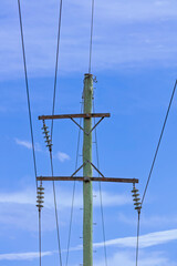 Photograph of the top cable section of an old style wooden electricity transmission line support pole typically used in regional parts of Australia.