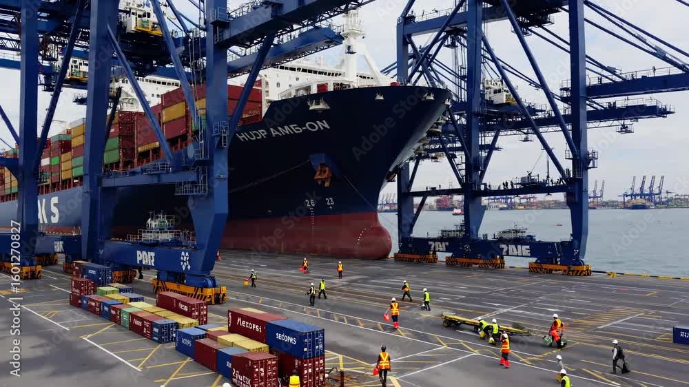 Aufkleber high-angle video shot of a bustling port with cranes unloading a cargo ship, capturing the dynamic m