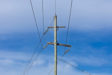 Photograph of the top cable section of an old style wooden electricity transmission line support pole typically used in regional parts of Australia.