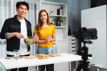 Cooking show live streaming with two chef influencers making mixed salad, all ingredients with...