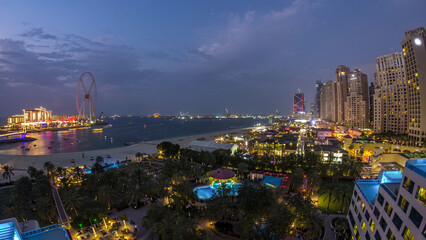 Obraz premium Aerial view of beach and tourists walking in JBR with skyscrapers day to night timelapse in Dubai, UAE
