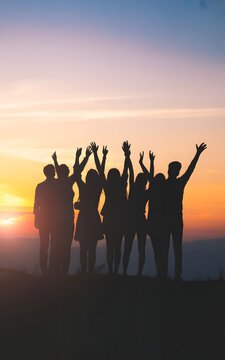 Joyful silhouettes of friends celebrating at sunset