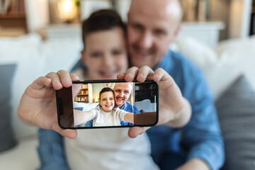 Dad, son and portrait in home for selfie, bonding and profile picture together with happiness or care. Man, child and face in lounge for memory, relax and social media with smile, love or family time.