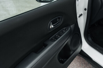 Interior close-up of Honda car door with electric window controls, speaker and handle – black panel design captured for automotive interior detailing, functionality and ergonomic layout content
