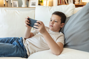 Couch, boy with phone for games, movies or streaming cartoon weekend in home. Entertainment, relax or kid gaming on sofa with mobile connection for video, playing online or addiction.