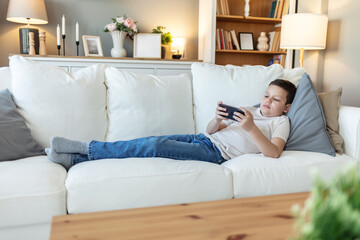 Cute boy, streaming and smartphone for educational games, growth and development in home. Kids, mobile tech and esports for creativity, fun and social media with application, download and playing.