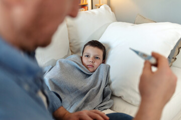 Sick, cold and flu of sick child with caring and loving parent taking temperature of his son....