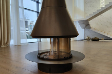 Modern design of a cylindrical fireplace, in the interior of the living room of a luxurious...