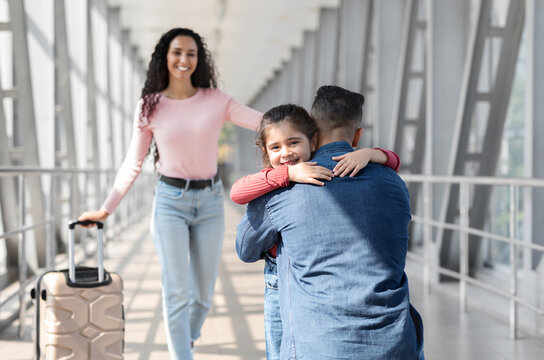 Long Awaited Meet. Happy Man Meeting With Wife And Daughter At Airport After Their Arrival, Cute Happy Little Girl Embracing Her Dad And Smiling, Cuddling At Terminal, Selective Focus With Free Space - Powered by Adobe