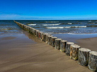 Breakwaters made of piles driven into the seabed on a Baltic Sea beach in Rogowo, Poland