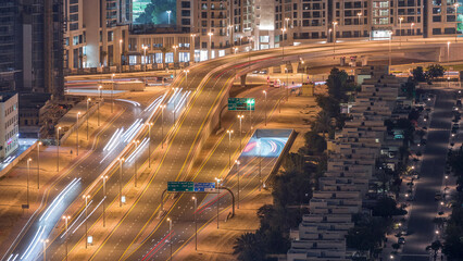 Traffic on the road in Jumeirah Lakes Towers district aerial night timelapse.