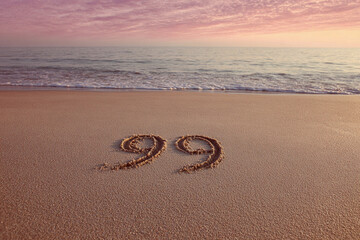 Number 99 Etched in Flat Beach Sand with Peach Sky and Gentle Tones – Serene Horizontal Morning Beach Scene  