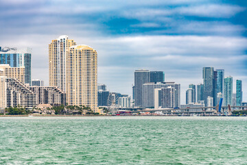 Downtown Miami and Brickell skyline, featuring Port Boulevard and the Skyviews Miami Wheel against a dramatic sky.