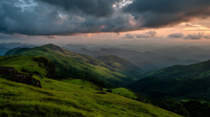 Obraz premium Rolling green hills landscape at sunset with scenic view of valleys and mountains under cloudy skies