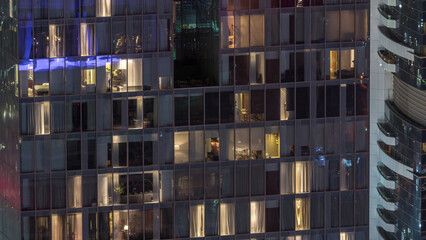 Night view of exterior apartment tower timelapse. High rise skyscraper with blinking lights in windows