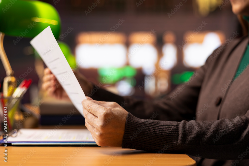 Poster mature woman focused on university level reading and studying, surrounded by textbooks and documents