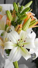 Obraz premium bouquet of white and orange lilies in a white wrapper close-up