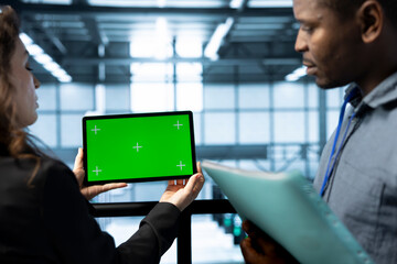 Team of admins in data center using green screen tablet, refining server virtualization strategies....