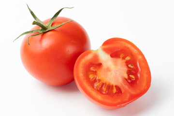 Fresh red tomato with green stem next to a halved tomato, showcasing juicy interior on a white background. Perfect for food, health, and culinary themes.