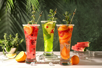 Modern still life with alcoholic cocktail of watermelon, apricot lemon, ice, tequila, vodka and...