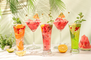Modern still life with alcoholic cocktail of watermelon, apricot lemon, ice, tequila, vodka and...
