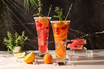 Cold homemade lemonade, sangria or cocktail with mint, watermelon, apricot, lemon and fruits,...