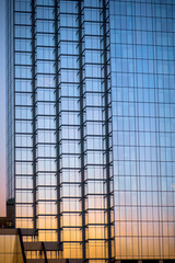 Close up view of Glass building exterior view with sunset sky reflection.