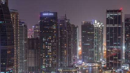 Fototapeta premium Residential and office buildings in Jumeirah lake towers district night timelapse in Dubai